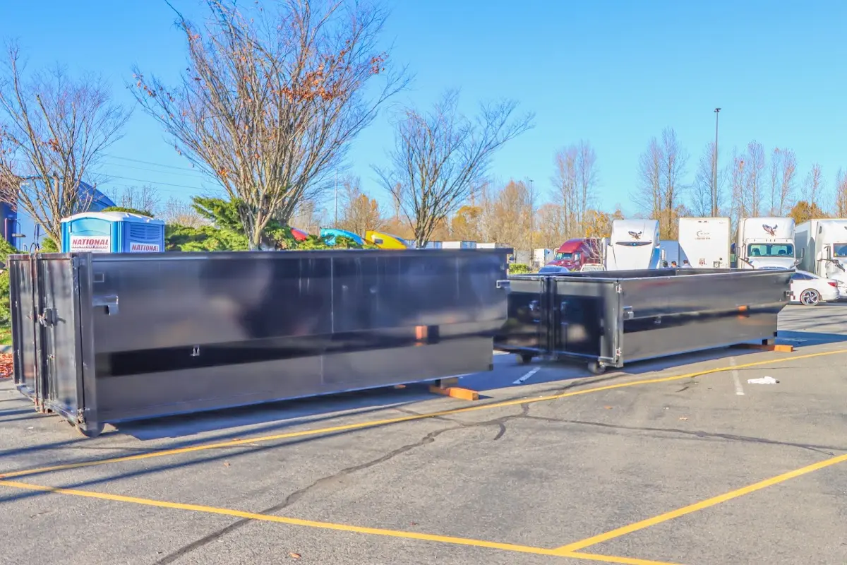 Professional dumpster rental service with roll-off container on residential driveway in De Queen